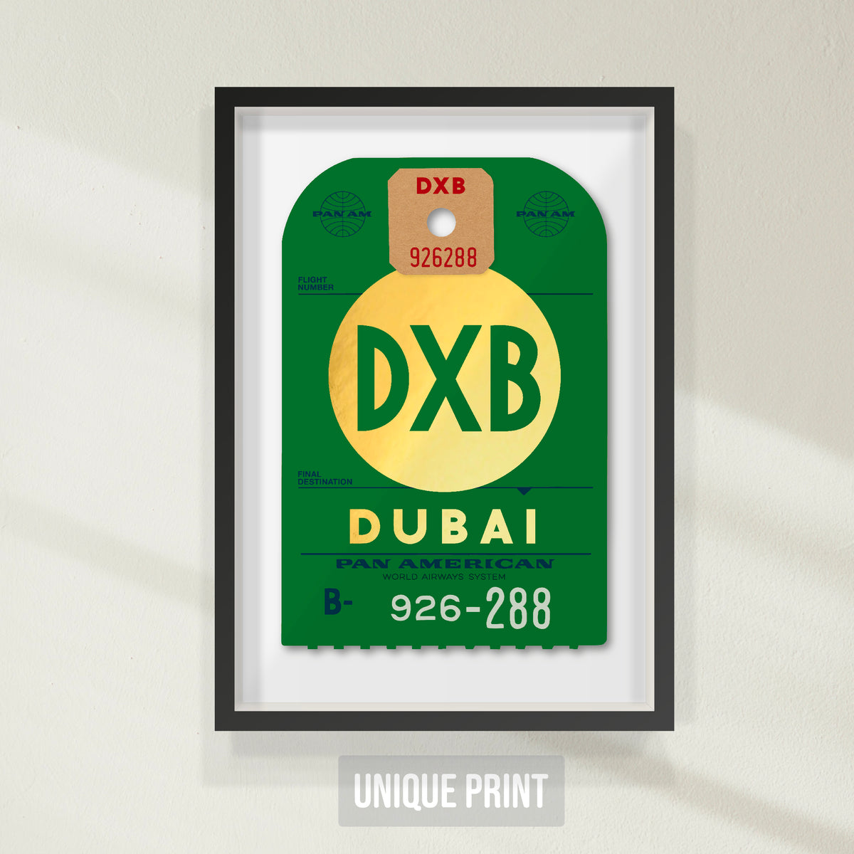 One-off (unique print) archival print of Pan Am “Dubai” luggage tag by Ella Freire, inspired by the 1960s design, supersized to 55 × 83 cm, printed on shiny gold paper, float-mounted and framed to enhance the 3D effect; officially Pan Am licensed with signed certificate.