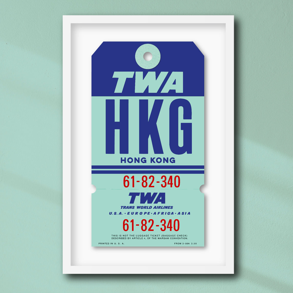 Limited-edition archival print of a TWA “Hong Kong” luggage tag by Ella Freire, inspired by the original 1960s design, supersized in one framed size only, float-mounted to enhance its three-dimensional effect; officially licensed by TWA (American Airlines) with signed certificate included.