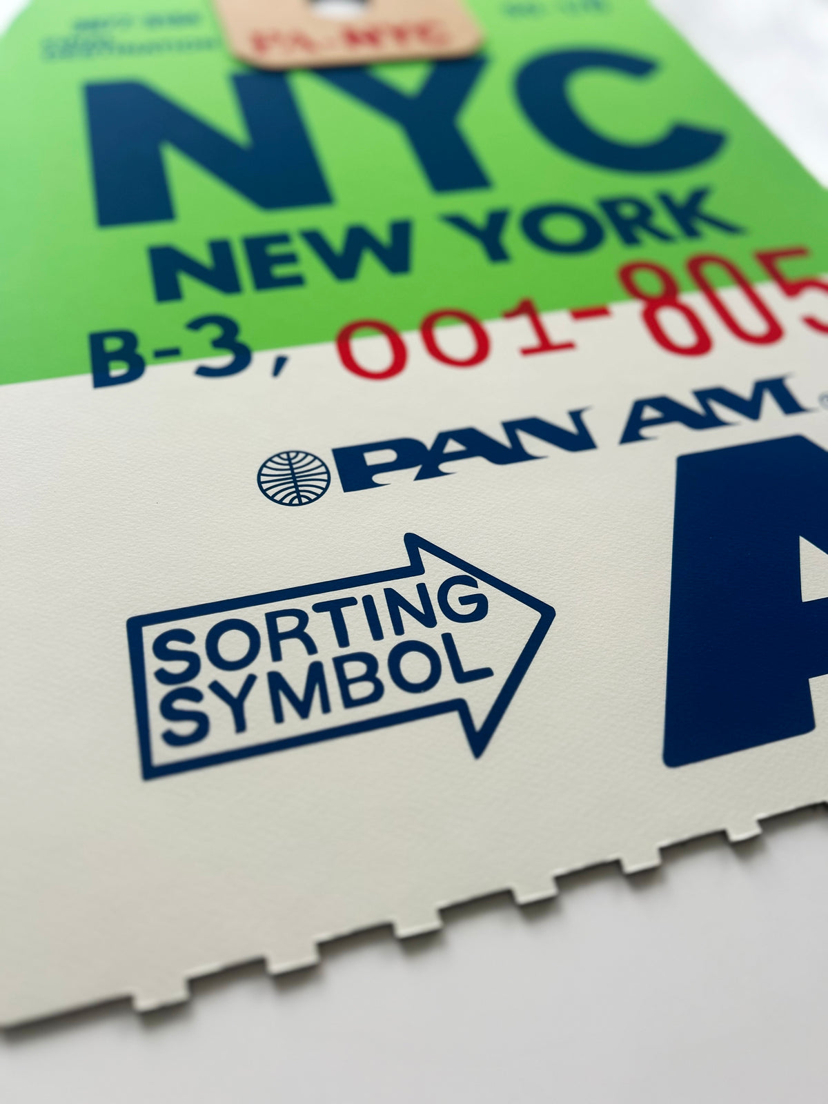Limited-edition archival print of a Pan Am “NYC New York” luggage tag by Ella Freire, inspired by the original 1960s design, supersized in two framed sizes, float-mounted to enhance its three-dimensional effect; officially licensed by Pan Am with signed certificate included.