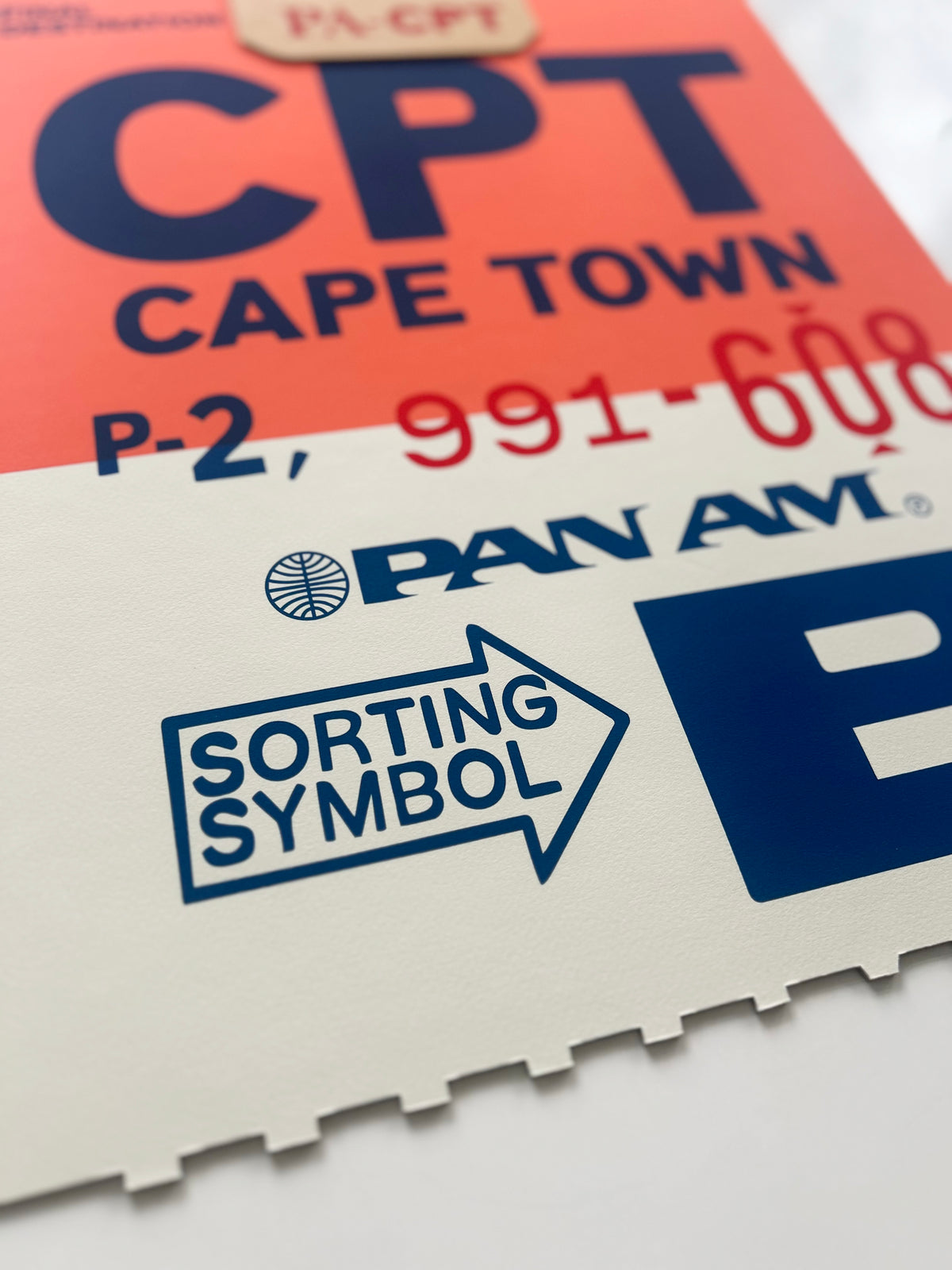 Limited-edition archival print of a Pan Am “Cape Town” luggage tag by Ella Freire, inspired by the original 1960s design, supersized in two framed sizes, float-mounted to enhance its three-dimensional effect; officially licensed by Pan Am with signed certificate included.