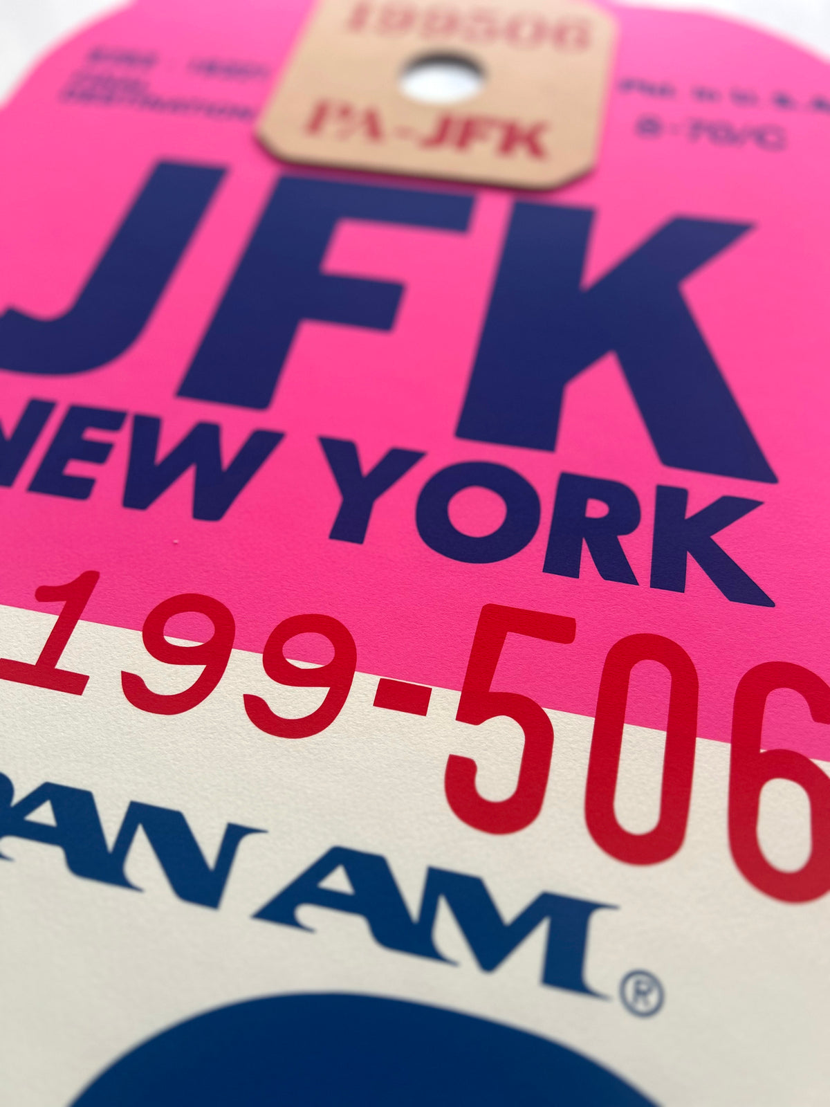 Limited-edition archival print of a Pan Am “JFK New York” luggage tag by Ella Freire, inspired by the original 1960s design, supersized in two framed sizes, float-mounted to enhance its three-dimensional effect; officially licensed by Pan Am with signed certificate included.