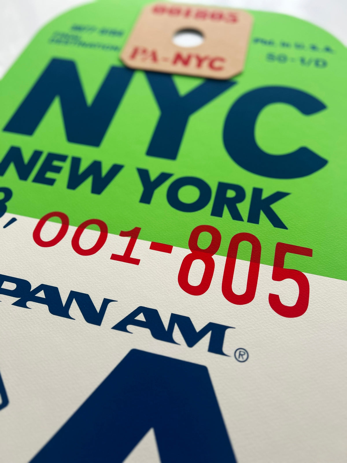 Limited-edition archival print of a Pan Am “NYC New York” luggage tag by Ella Freire, inspired by the original 1960s design, supersized in two framed sizes, float-mounted to enhance its three-dimensional effect; officially licensed by Pan Am with signed certificate included.