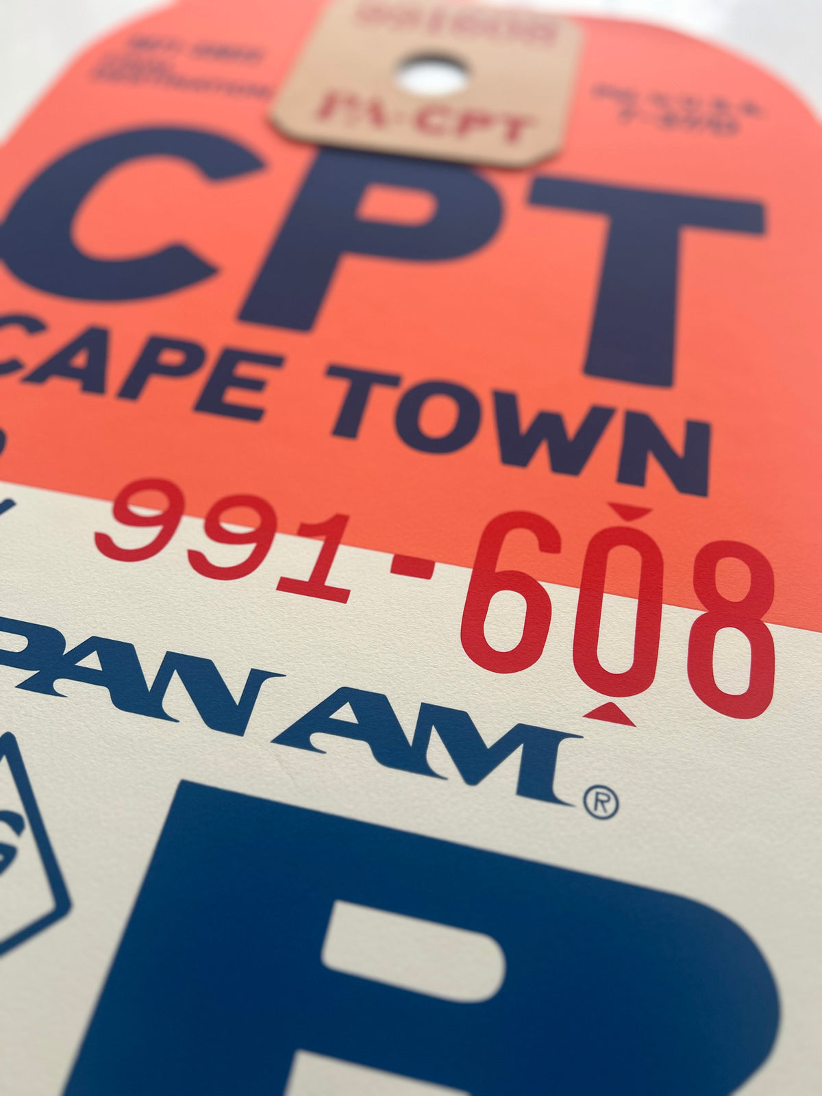 Limited-edition archival print of a Pan Am “Cape Town” luggage tag by Ella Freire, inspired by the original 1960s design, supersized in two framed sizes, float-mounted to enhance its three-dimensional effect; officially licensed by Pan Am with signed certificate included.