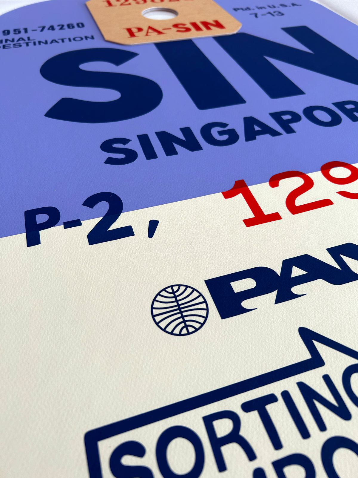 Limited-edition archival print of a Pan Am “Singapore” luggage tag by Ella Freire, inspired by the original 1960s design, supersized in two framed sizes, float-mounted to enhance its three-dimensional effect; officially licensed by Pan Am with signed certificate included.